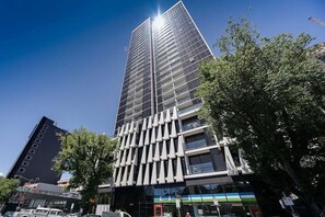 Un edificio alto y moderno con fachada enrejada y ventanas grandes.