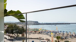 Ein Balkon mit Blick auf einen Strand, eine Straße und eine Skyline.