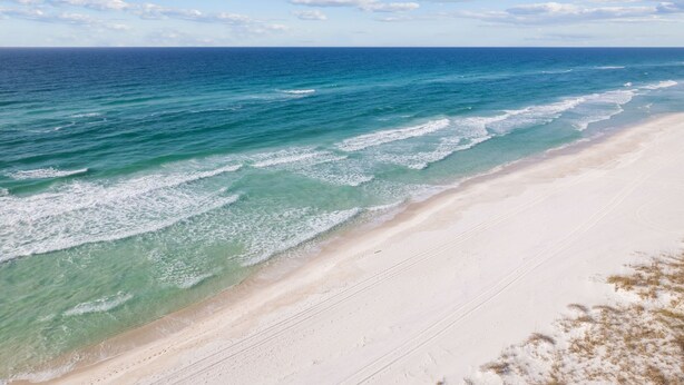 Uma praia com águas turquesa cristalinas e uma orla arenosa.