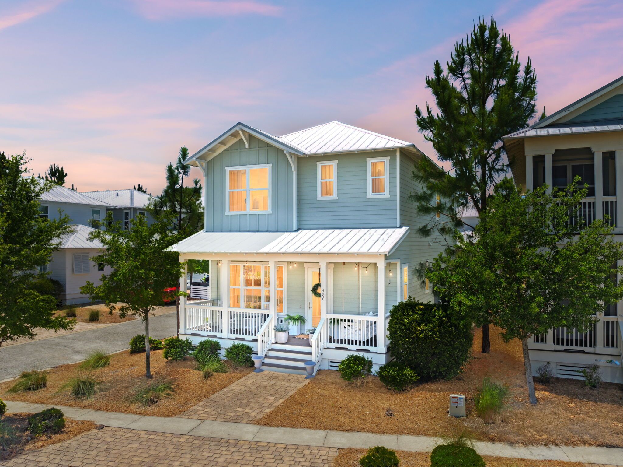 A two-story house with a porch, a garage, and a driveway.