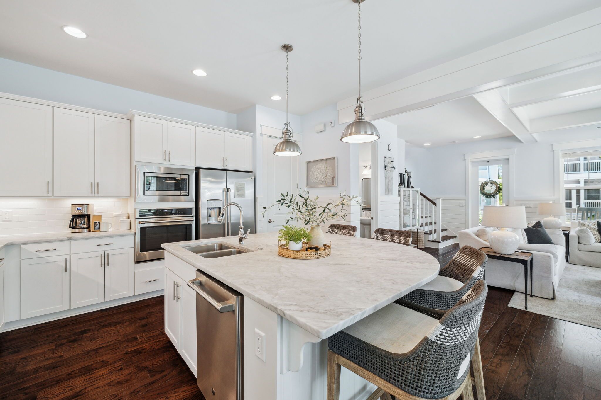 A spacious kitchen with white cabinets, stainless steel appliances, and a large island.