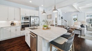 A spacious kitchen with white cabinets, stainless steel appliances, and a large island. - ☀️ 6 Beds | Golf Cart | Near Beach (Santa Rosa Beach)