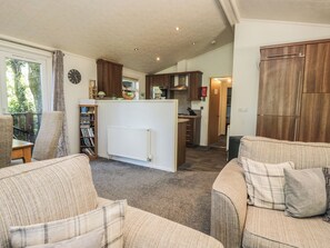 A cozy living room with a fireplace, a dining area with a table and chairs, and a kitchen with wooden cabinets.
