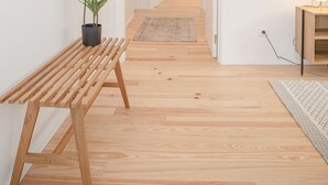 A hallway with a wooden bench, a potted plant, a wall-mounted mirror, a light fixture, and a framed artwork. - Liiiving - Modern & Glam Apartment M (Porto)