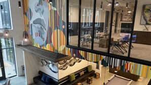 Un área de lounge moderna con mesa de billar, asientos y vistas al exterior.