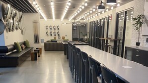Una cocina moderna con una barra alargada, taburetes y una zona de estar con sofá y cojines.