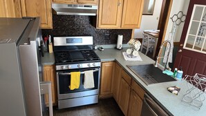A kitchen with wooden cabinets, a stainless steel stove, and a dishwasher. - Beautiful Lake home-5 minute walk to the Public Beach Area, (Rochester)