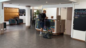 A modern interior with a reception desk, seating area, and a large window.
