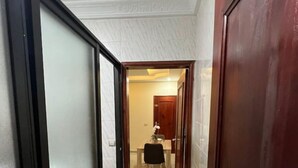 A hallway with a tiled floor leading to a dining area with a table and chairs. - Appart Cozy Riviera 4 Verdant (Abidjan)