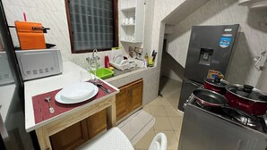 A compact kitchen with a sink, countertop, and a refrigerator. - Appart Cozy Riviera 4 Verdant (Abidjan)
