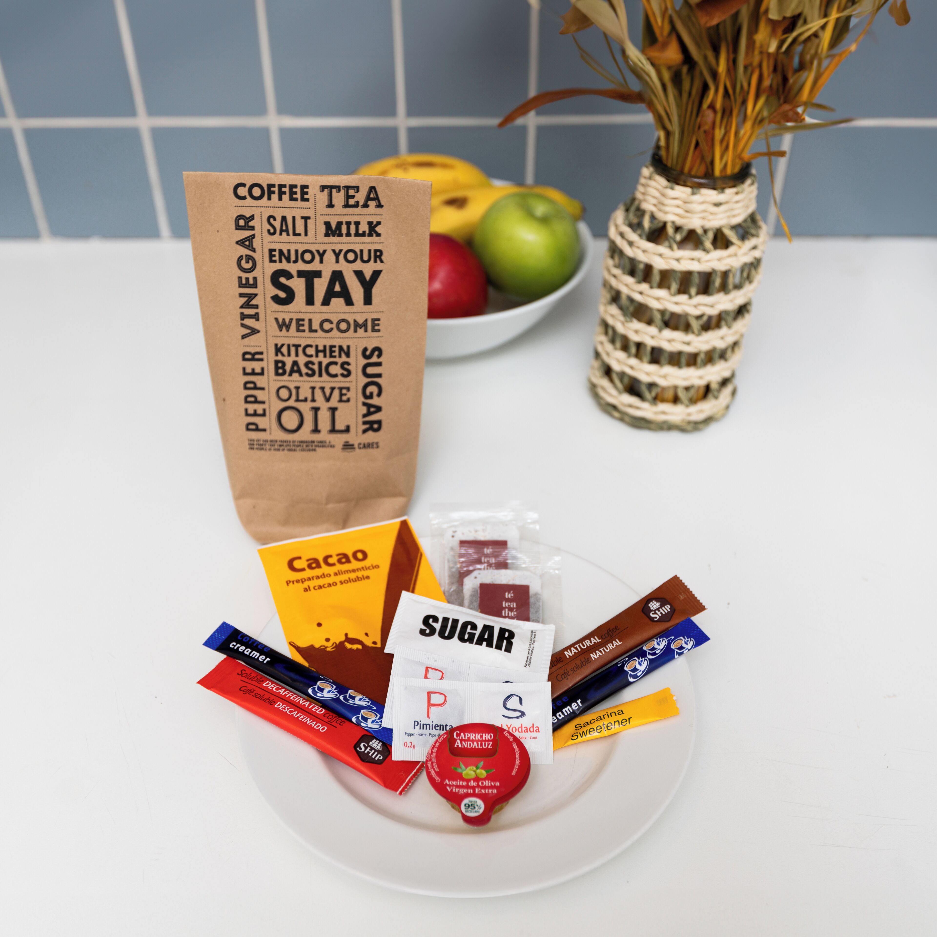 A kitchen counter with a variety of food items and a bag of coffee essentials.