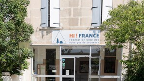 A building with a sign reading "HI! FRANCE Fédération Unie des Alpes de Jeannesse".