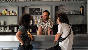 Zona de bar con estantes llenos de botellas y copas.