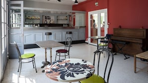 Un comedor con barra, piano y ventilador de techo.