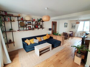 Un salon comprenant un canapé, une table basse et des étagères où sont disposés divers objets.
