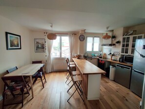 Une cuisine de taille réduite avec un coin repas, un plancher en bois et une vue par la fenêtre.