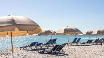 On the beach, white sand, sun loungers, beach towels