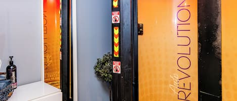 A bathroom with a mirror, toiletries, and a door with 'Revolution' branding.