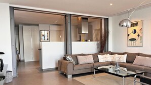 A modern living room with a sofa, coffee table, and a glass partition. - 20. Bright & lovely apt with incredible sea view, in the heart of the old town (Antibes)