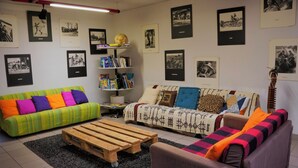 Un salon avec deux canapés, une table basse et une bibliothèque.