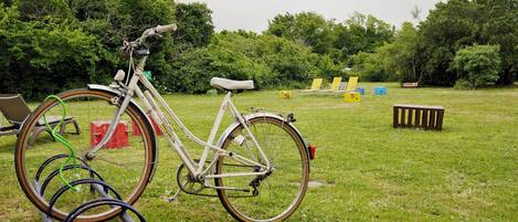 Een fiets geparkeerd op gras, met een stoel en een tafeltje ernaast.