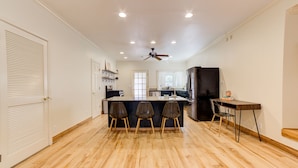 A modern kitchen with a central island, wooden flooring, and a ceiling fan. - Private Apartment with pool, 5 min to downtown (Tulsa)