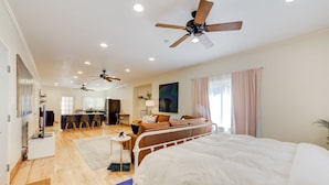 A spacious bedroom with a large bed, a ceiling fan, and a view of the living area. - Private Apartment with pool, 5 min to downtown (Tulsa)