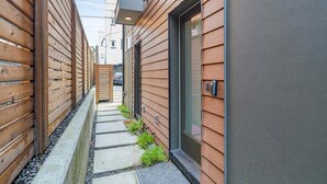 Un callejón estrecho con paredes de madera y un sendero de hormigón.