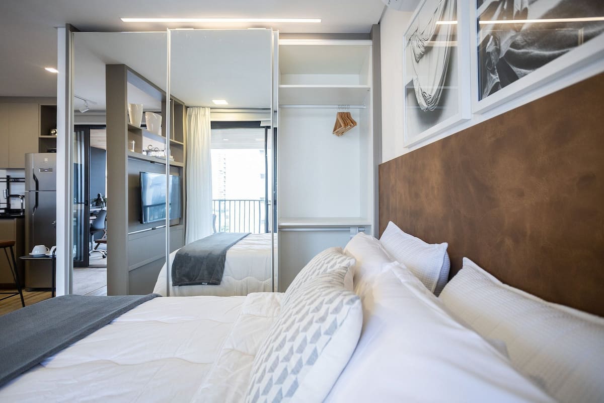 Una habitación de hotel con cama, televisión, escritorio y armario.