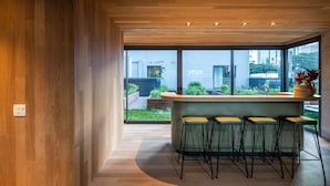 Una cocina moderna con barra, ventanas amplias y vistas a la ciudad.