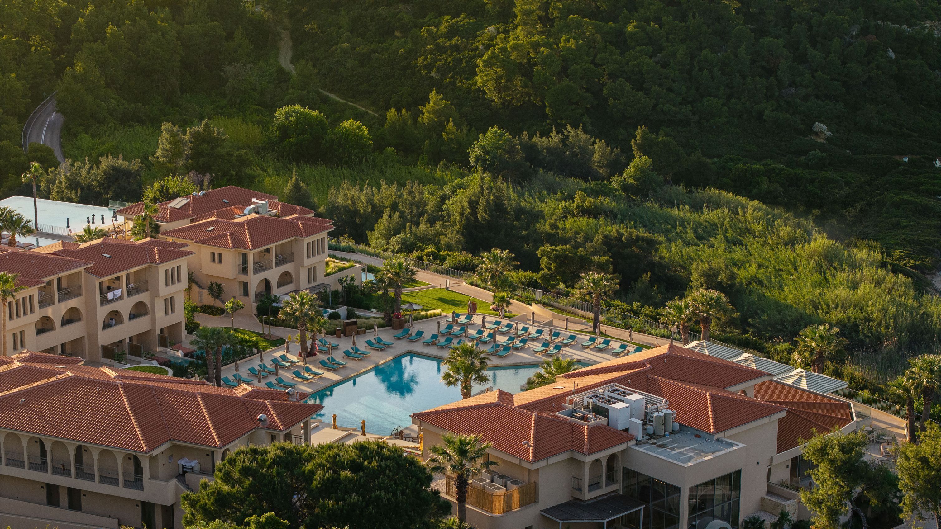 Un resort con piscina, varias construcciones y abundante vegetación.
