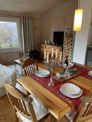 Enjoy meals in this inviting dining area with a table for four, featuring a centerpiece of candles and a view of the outdoors.