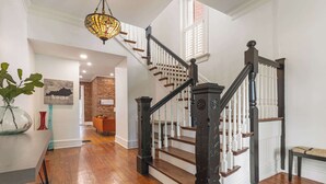 A staircase with dark wooden balusters and white railings, leading to an upper floor.