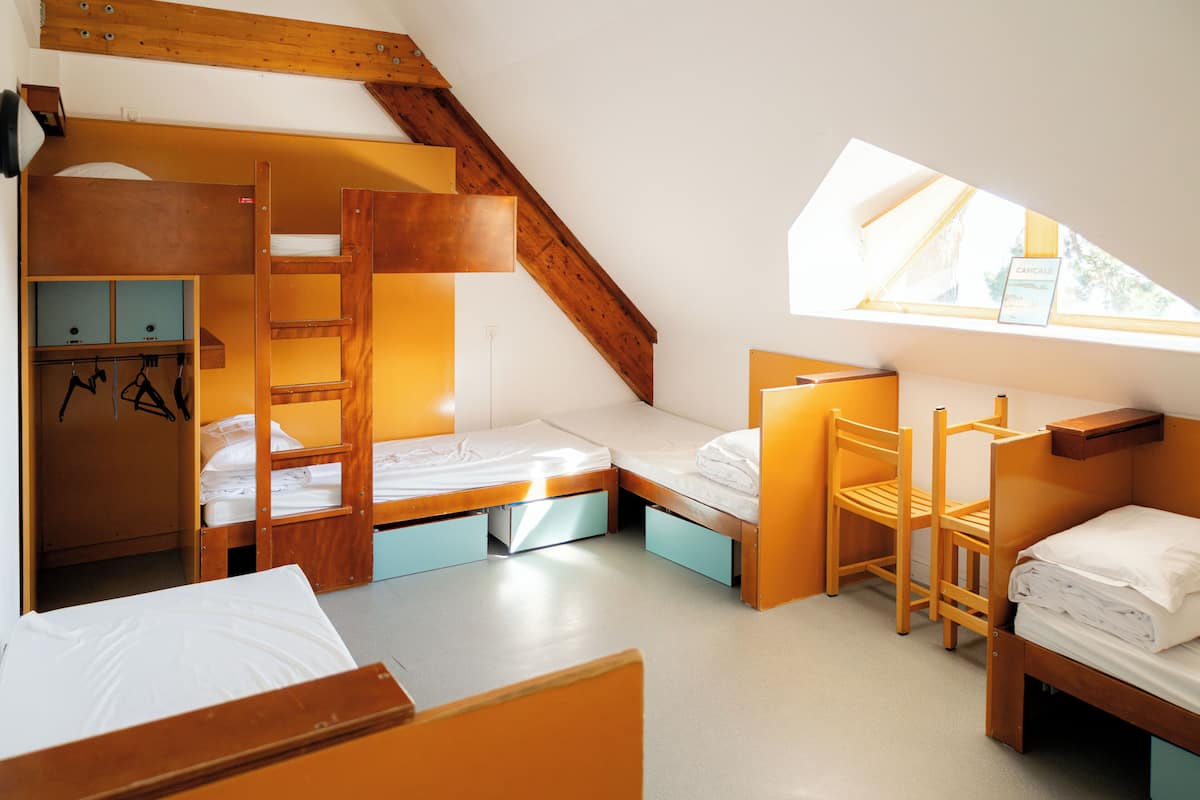Un dormitorio con literas, un escritorio y una silla.