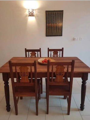 Enjoy meals in this dining area with a table and chairs, a beautiful piece of artwork, and a convenient power outlet.