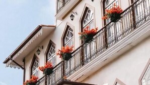 Um edifício com vários andares e varandas decoradas com floreiras.