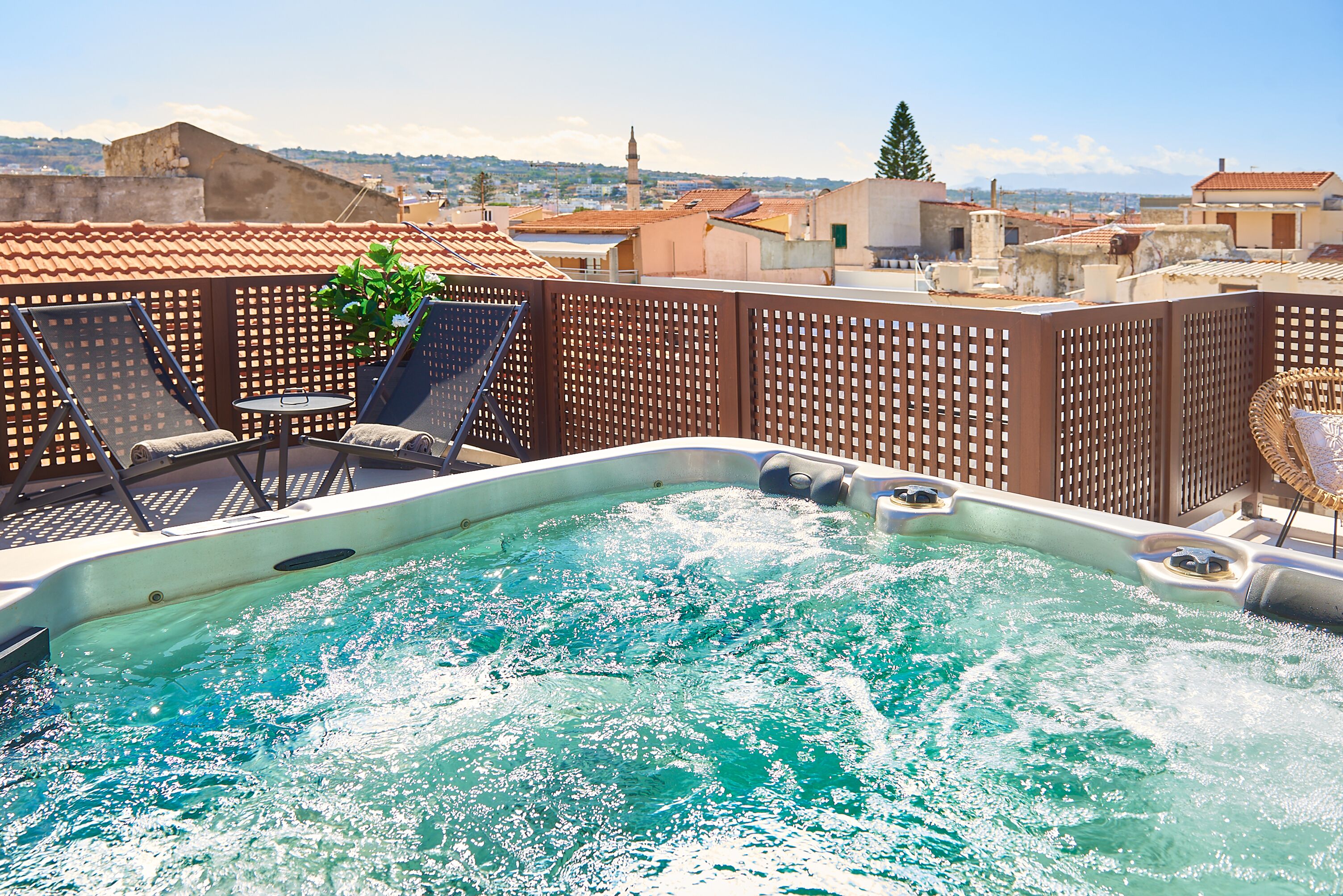 A rooftop pool with lounge chairs and a view of the cityscape.