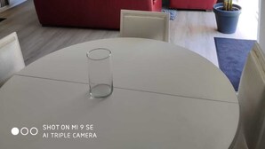 Una sala de estar moderna con pared de piedra, un sofá rojo y una mesa de comedor.