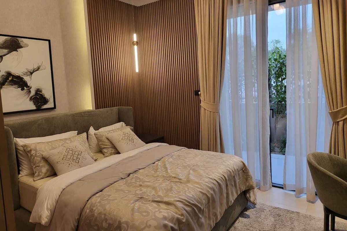 Une chambre à coucher avec un lit, une chaise et une vue sur la verdure.