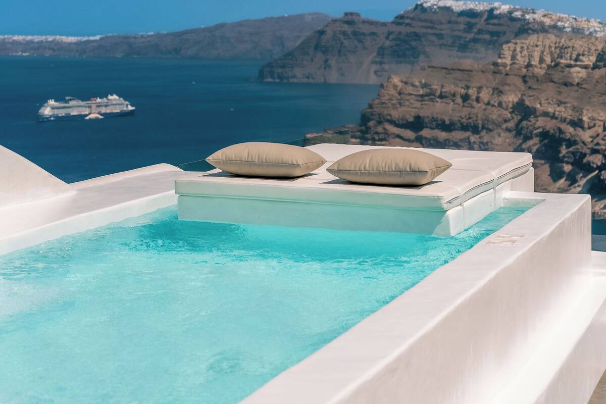 A pool with a view of the sea and cliffs.