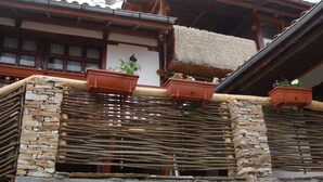 A traditional building with stone walls, wooden beams, and satellite dishes. - The Sharkov House (Satovcha)