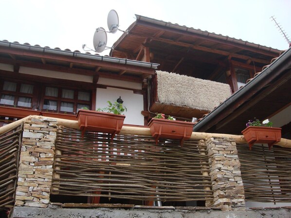 A traditional building with stone walls, wooden beams, and satellite dishes.