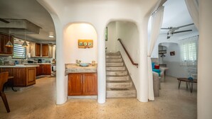 A spacious kitchen with wooden cabinets, a central island, and a dining area with a table and chairs. - La Casona Blanca Location Location  (Esperanza)