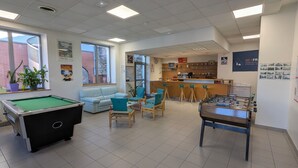 A recreational room with a pool table, foosball table, and seating area. - Auberge de Jeunesse HI Cherbourg (Cherbourg-en-Cotentin)