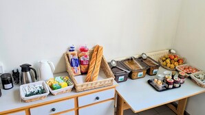 A breakfast buffet setup with various food items and condiments. - Auberge de Jeunesse HI Cherbourg (Cherbourg-en-Cotentin)