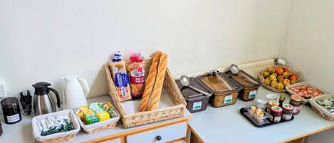 A breakfast buffet setup with various food items and condiments.