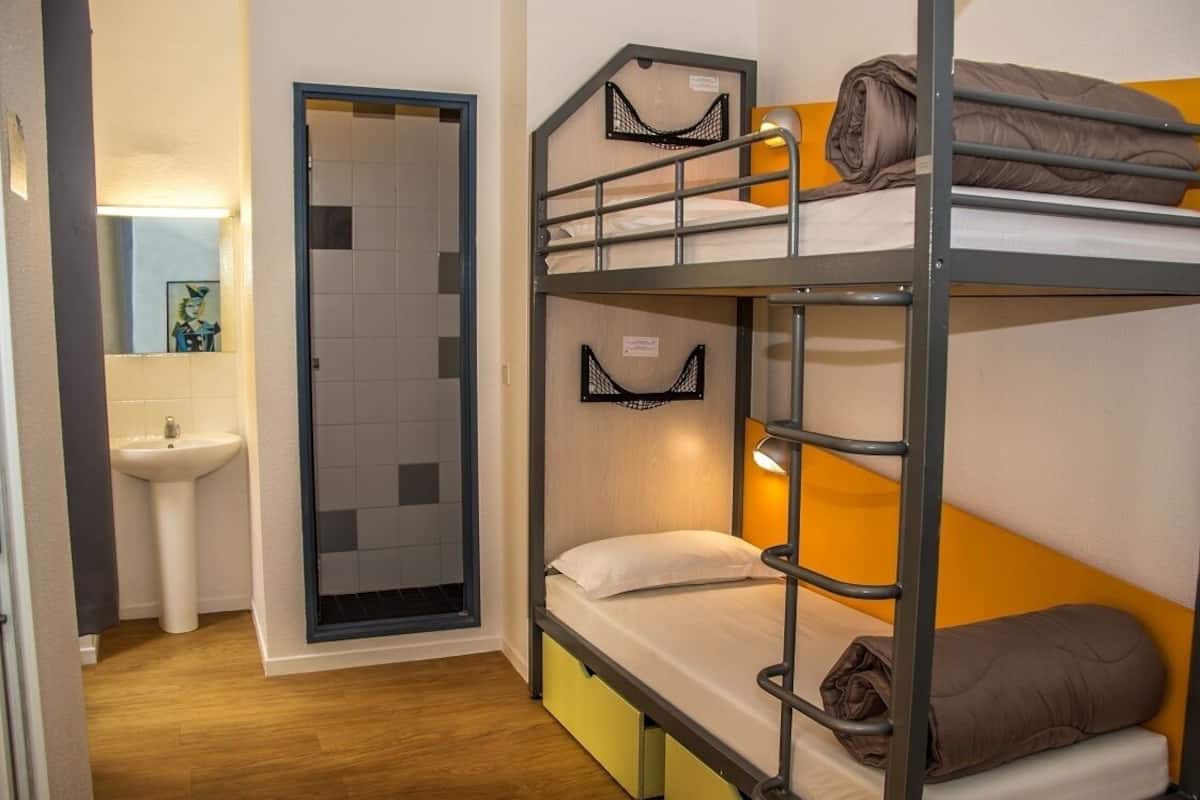 A bunk bed room with a sink and a mirror.