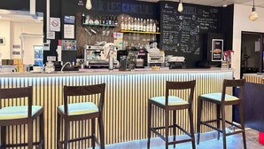 A bar area with a counter, bar stools, and a chalkboard menu. - Auberge de Jeunesse HI Nice - Les Camélias (Nice)