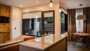 Una cocina moderna con una isla grande, armarios de madera e iluminación colgante.