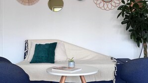 A living room with a sofa, a small round table, and a potted plant. - Auberge de jeunesse HI Clermont-Ferrand (Clermont-Ferrand)